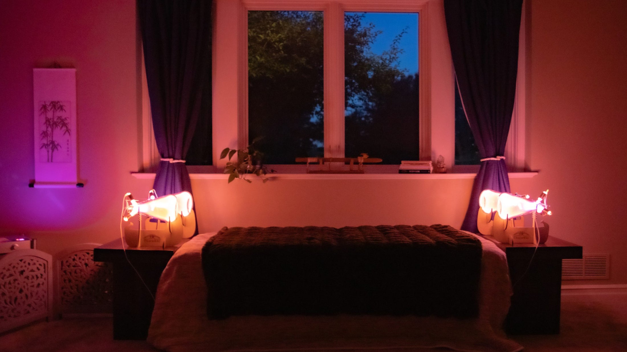 Cozy bedroom with purple lighting, bed, and theraphi.