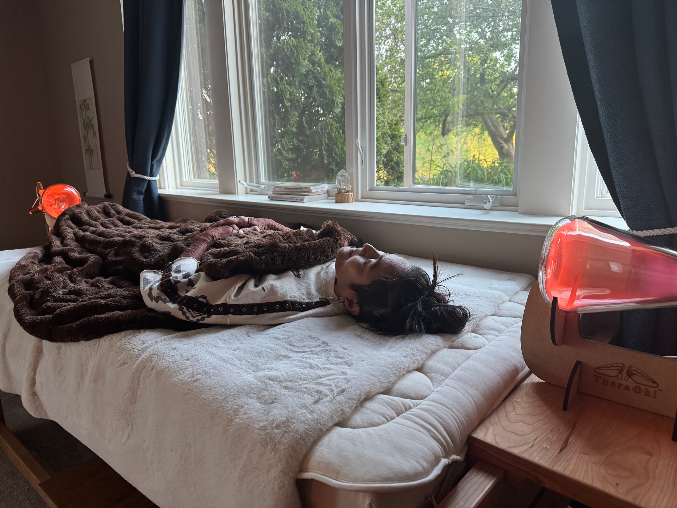 beautiful asian woman laying on a bed between theraphi bulbs