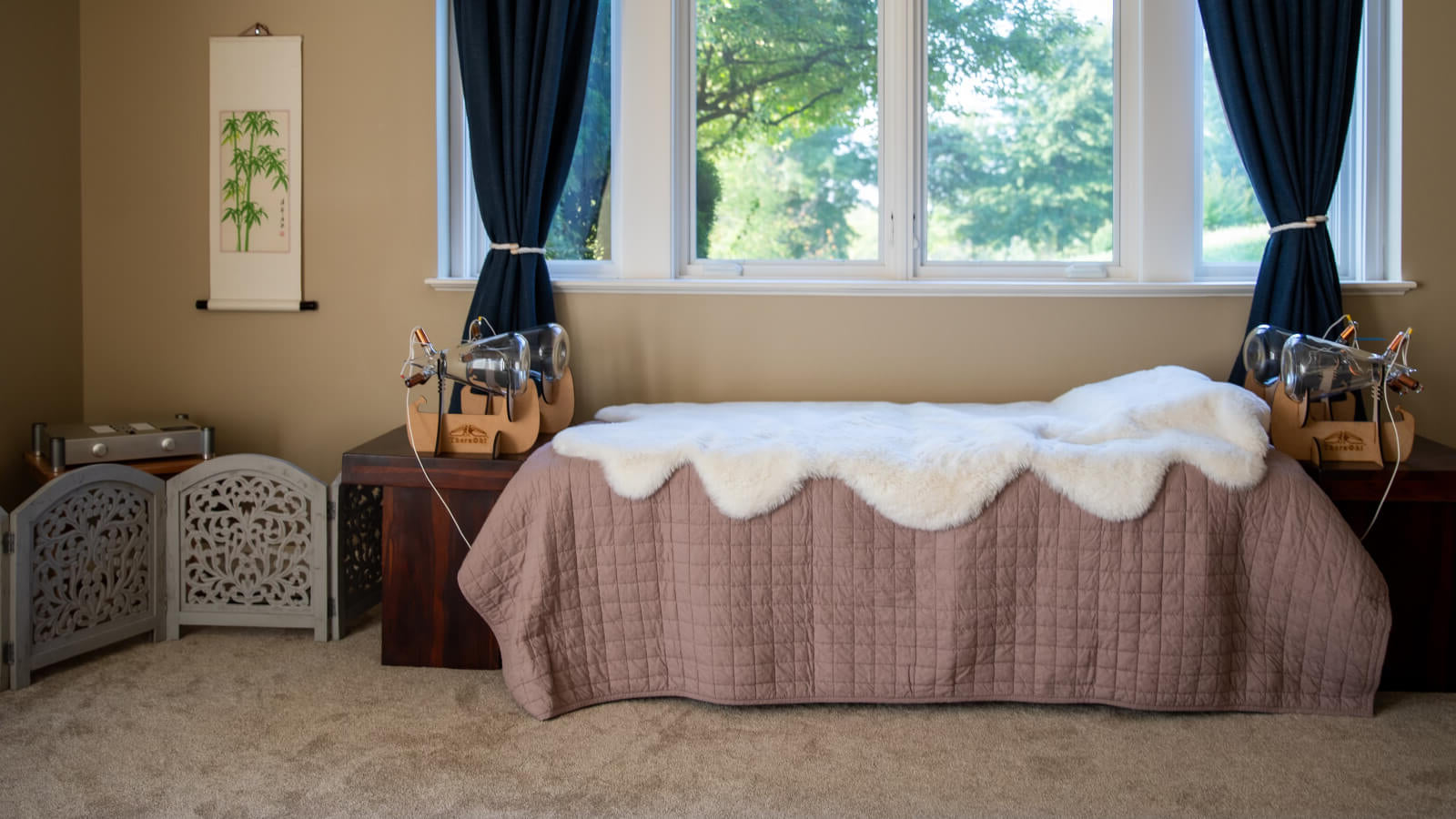 Theraphi setup in a bedroom with a pretty scalloped white fur throw in front of a window