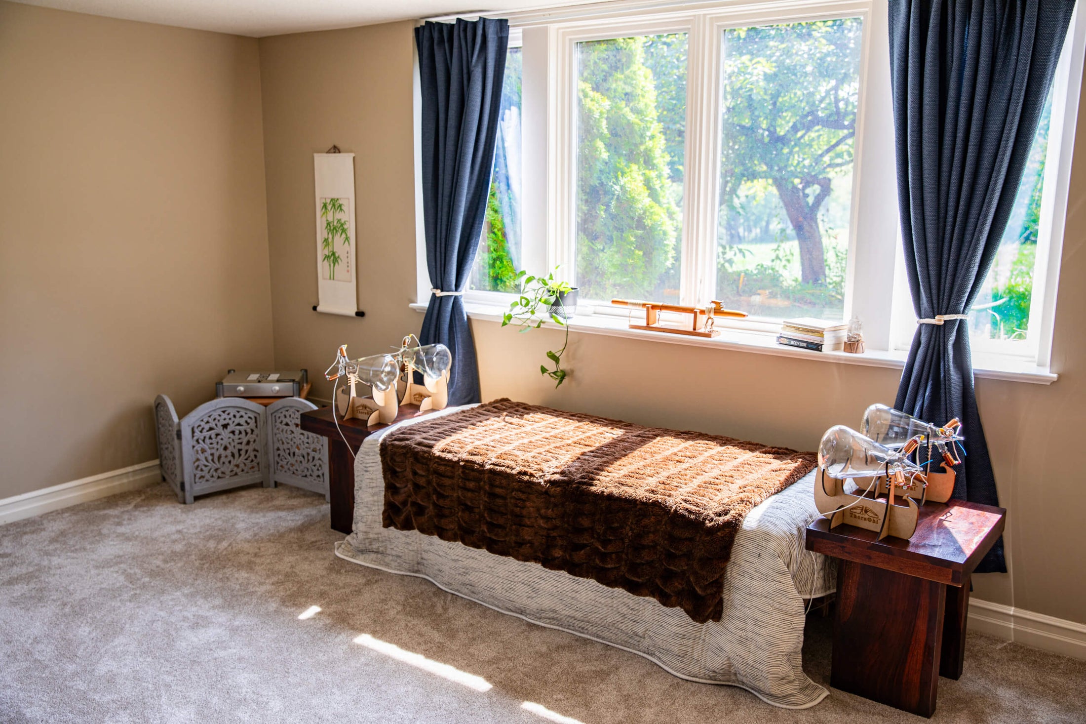 Theraphi setup with bed in front of a window with blue curtains