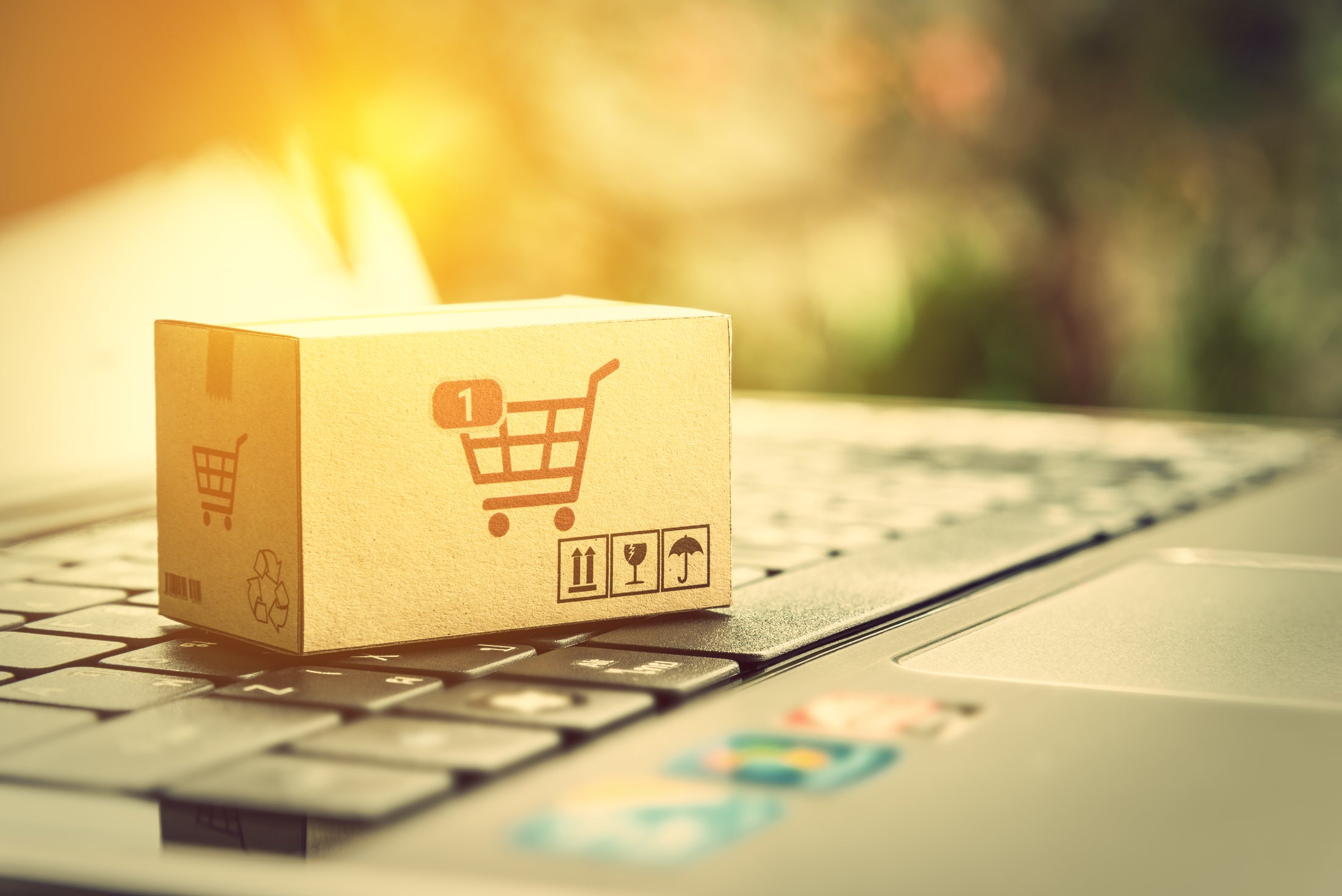 Small cardboard box with a shopping cart icon on a laptop keyboard