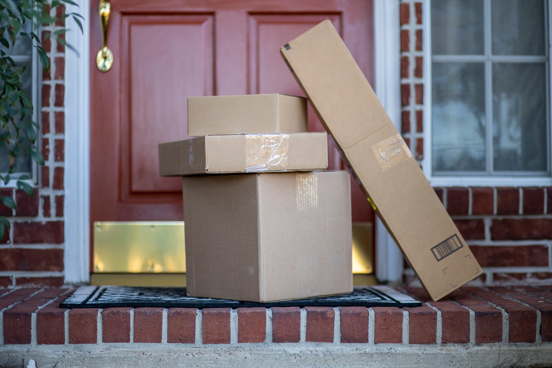 Stack of cardboard boxes on a doormat in front of a door
