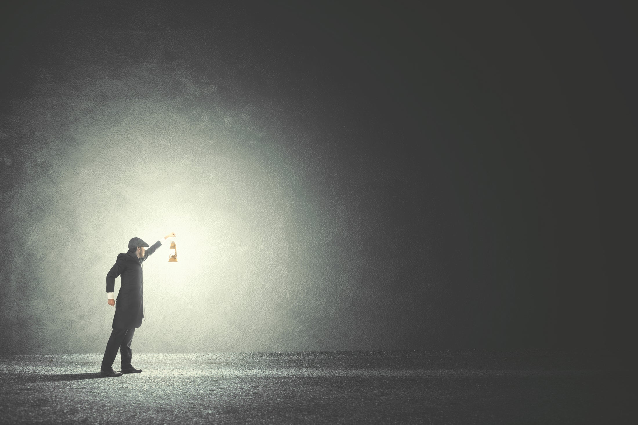 Person holding a lantern in a dark tunnel